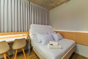 Una habitación de hotel con una cama, un escritorio y dos sillas.