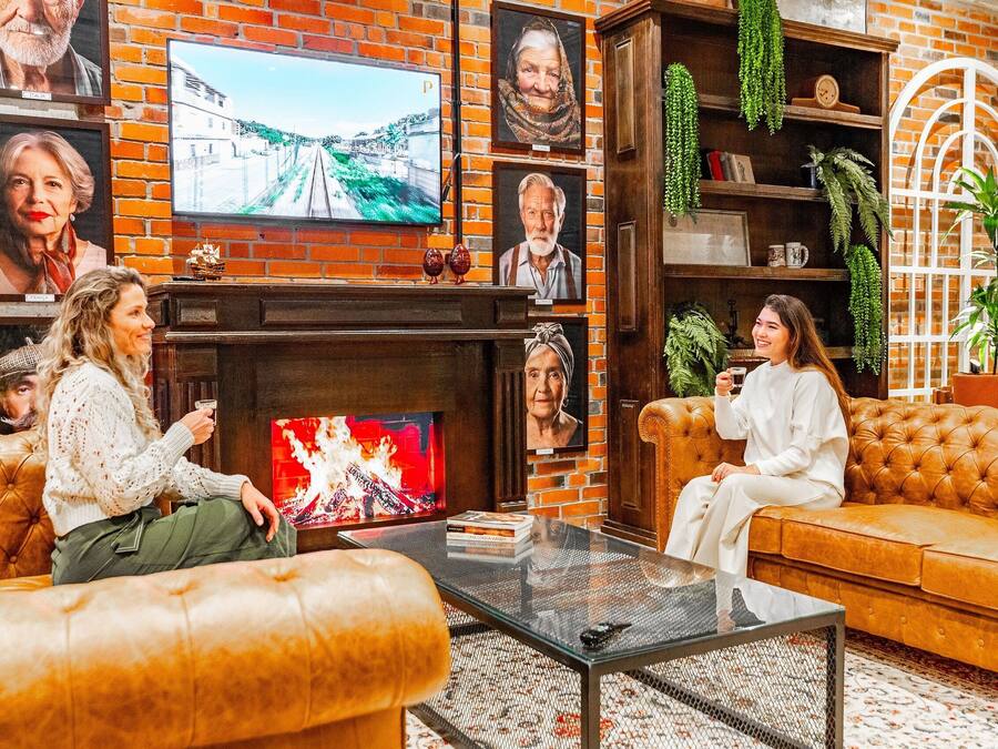 Ein gemütliches Wohnzimmer mit Ledersofas, einem Kamin und einem Fernseher.
