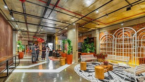 A spacious lobby with a polished floor, seating areas, and potted plants. - Linked Batel by Xtay (Curitiba)