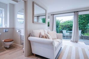 A modern bathroom with a toilet, a mirror, and a towel rack. - Bayview 3 - 2 Bedroom Chalet - Bayview Oxwich (Swansea)