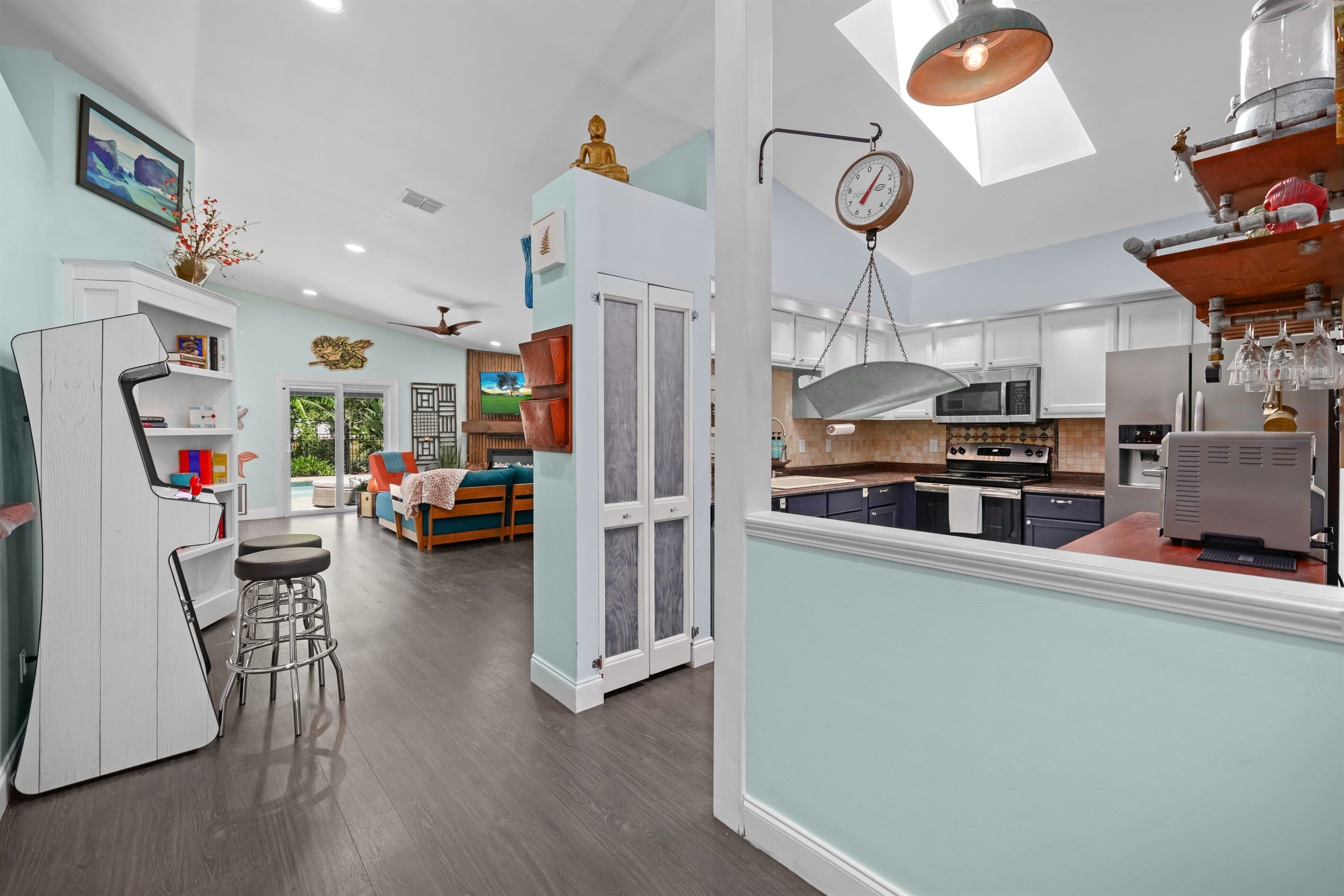 A modern kitchen with a dining area, a bar, and a living room with a view.