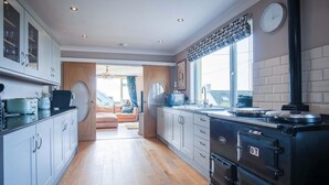 Cocina moderna con una estufa grande, armarios y vistas al área de estar.