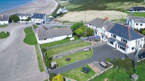 A coastal village with houses, a beach, and a road curving through the area.