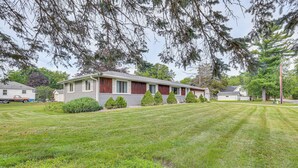 A single-story mobile home with a well-maintained lawn, several small trees, and a clear sky. - 12 Mi to Castle Rock Lake: Serene New Lisbon Home! (New Lisbon)