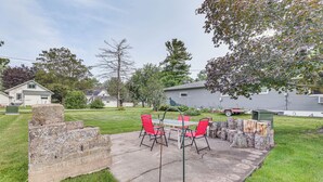 A patio with a table and chairs, surrounded by stone steps and a grassy lawn. - 12 Mi to Castle Rock Lake: Serene New Lisbon Home! (New Lisbon)