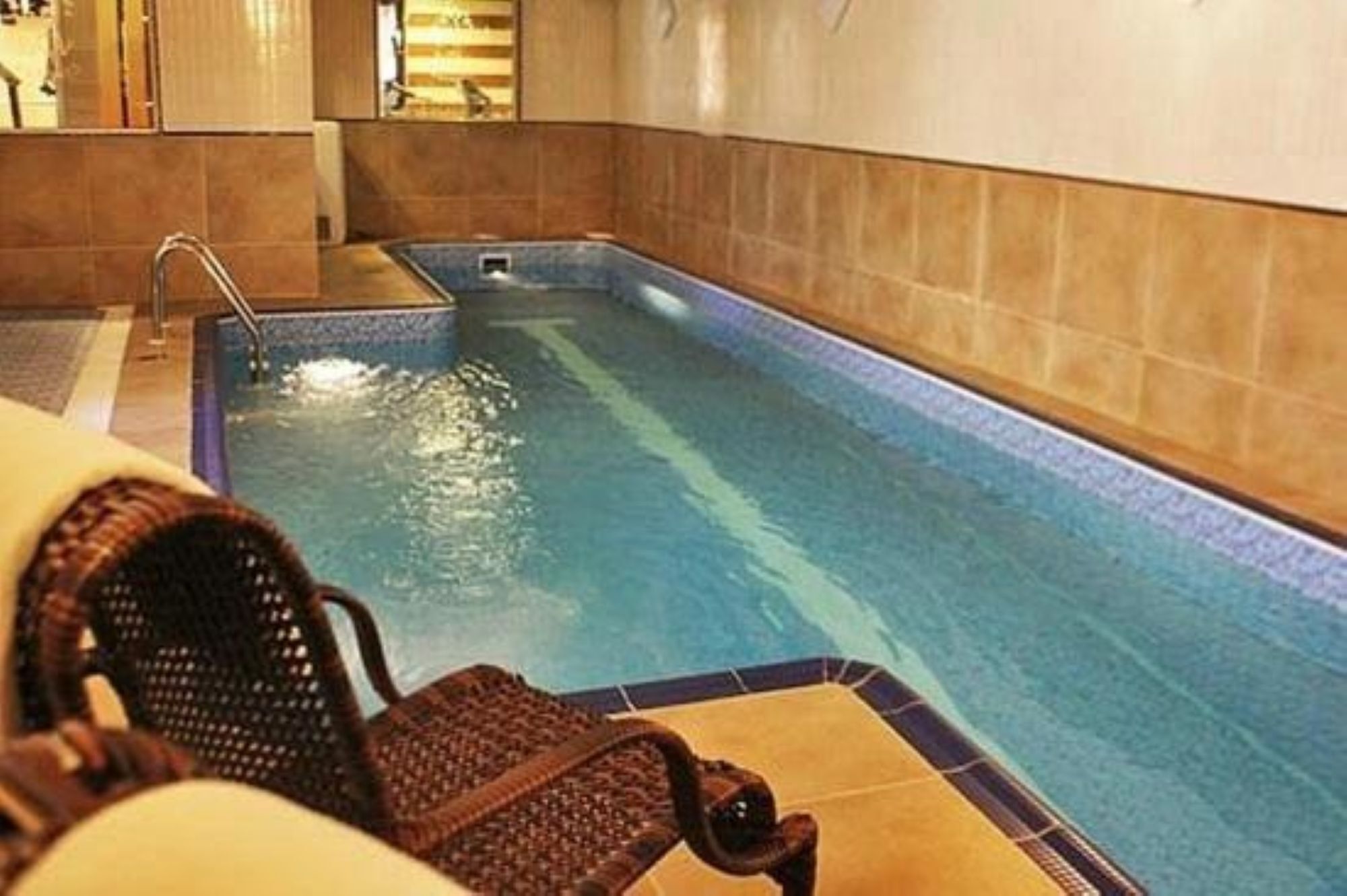 A swimming pool with a chair and a small water feature.