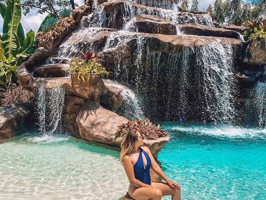 Una piscina al aire libre, sombrillas, tumbonas