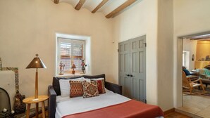 Ein Schlafzimmer mit Bett, Fenster, Tür und Lampe.