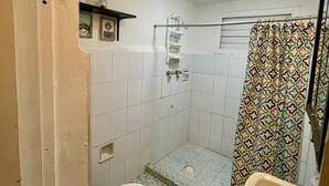 Een compacte badkamer met douche, toilet en wastafel.