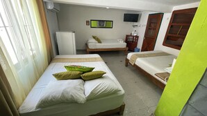 A hotel room with two beds, a television, a refrigerator, and a window with curtains. - Full house for 14 guests. A/C, TV, Wi-Fi, kitchen, dining and living room. Near beaches and downtown (Centro Isla Mujeres)