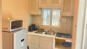 A compact kitchen with a microwave, refrigerator, sink, and stove. - Studio for 3 guests. A/C, Wi-Fi, TV, kitchen, balcony. Near ferry and beach. (Centro Isla Mujeres)
