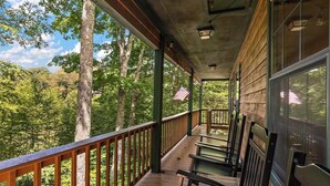 Une terrasse en bois avec des bancs donnant sur une zone boisée.