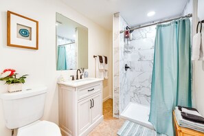 A bathroom with a toilet, sink, mirror, and shower area. - Feel the real VT! Lakes, hikes, a foodies delight! (Proctor)