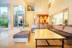 A modern living room with a large sectional sofa, a wooden coffee table, and a glass fireplace.