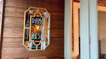 A wooden wall with a framed sign that reads 'DAME UN BESO.'