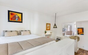 Una habitación de hotel moderna con una cama grande, un escritorio y una kitchenette.