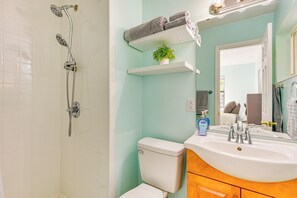 A bathroom with a shower, toilet, sink, and a mirror. - Emerald Coast Home: Outdoor Entertainment Area! (Mary Esther)