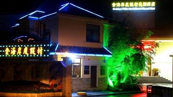 Un edificio con letreros iluminados y una entrada bien iluminada.