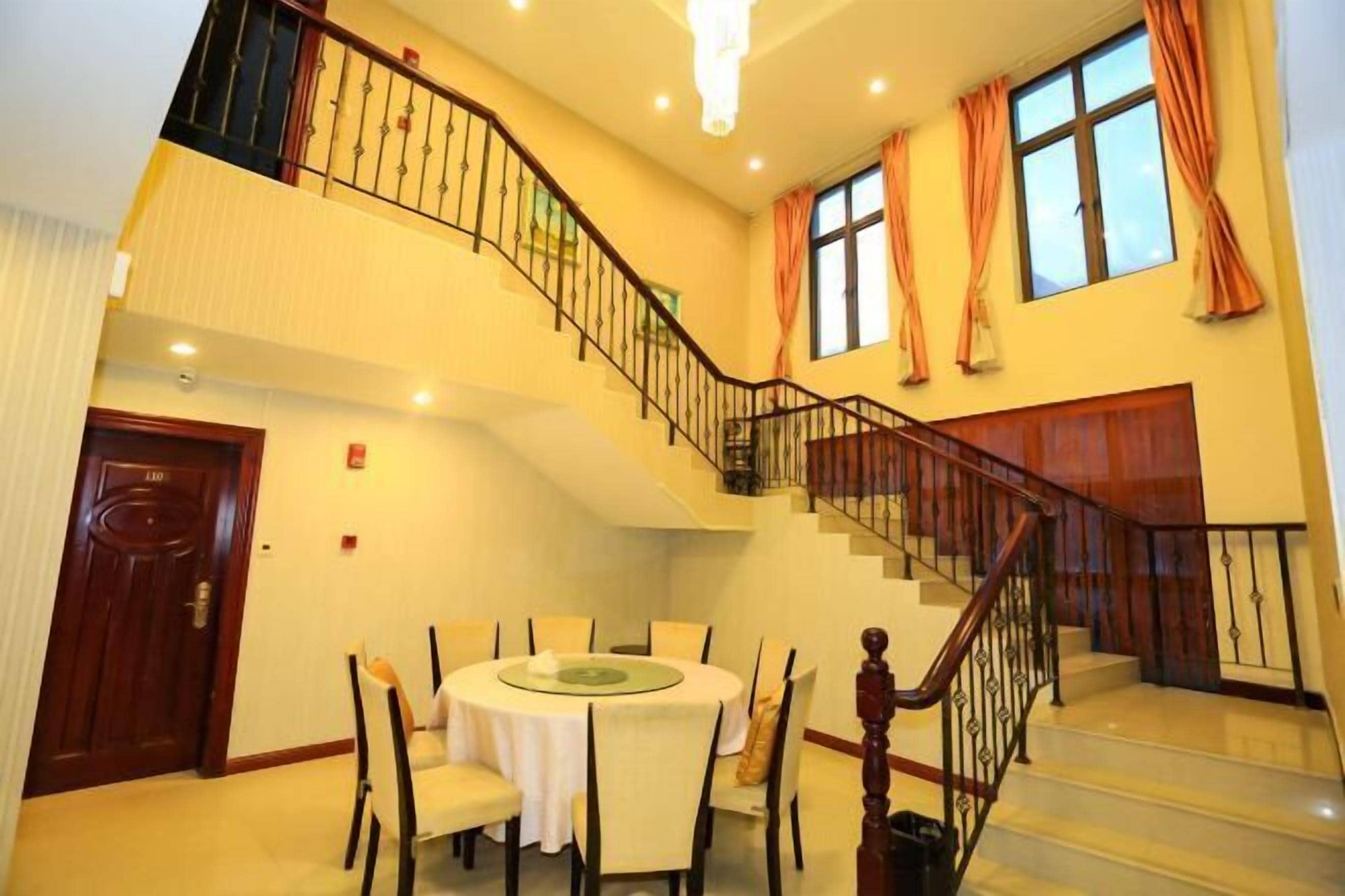 Interior de un hotel de varios niveles con comedor, una escalera y vistas al exterior.