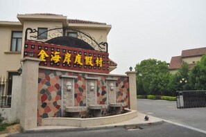 Une entrée d’immeuble avec une façade recouverte de carreaux et une enseigne dans une langue étrangère.