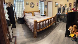 A bedroom with a wooden bed, a desk, and a chair. There are pictures on the wall and a window with curtains. - Charming 3-bedroom house in lovely Howard with AC, WiFi (Howard)