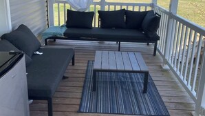 A covered porch with a sofa, a small table, and a bench. - Charming 3-bedroom house in lovely Howard with AC, WiFi (Howard)