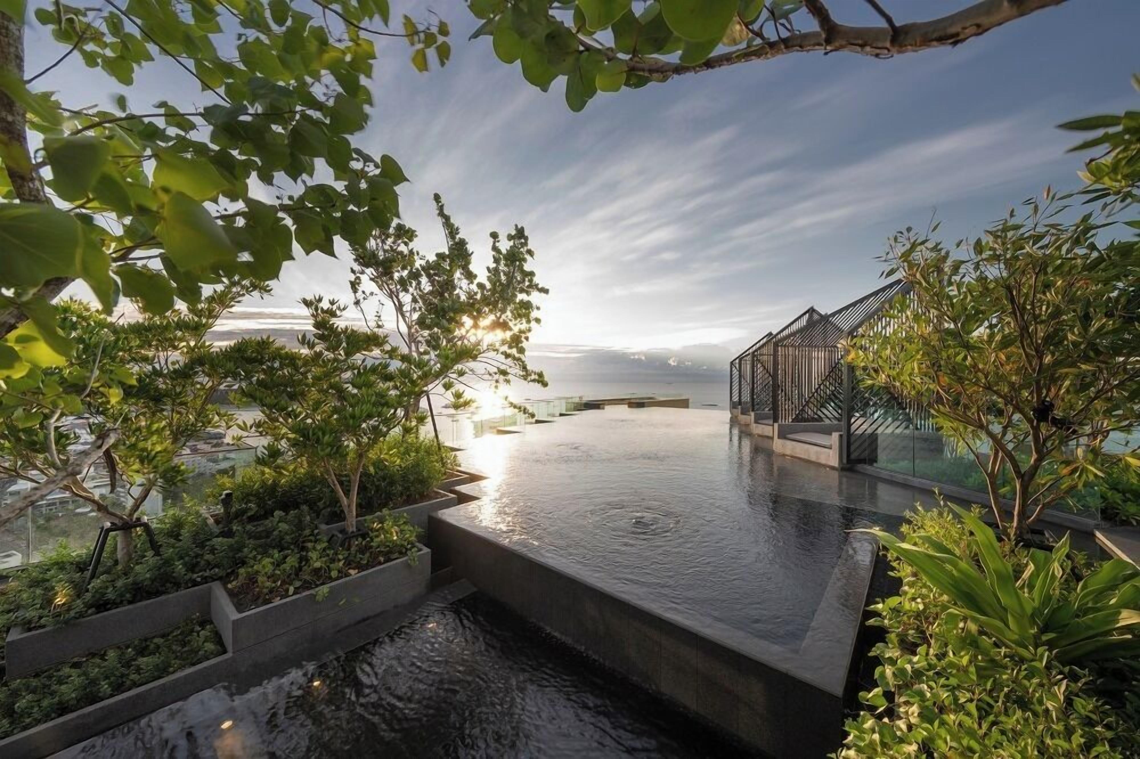 Een dakzwembad met een horizonuitzicht op de stadshemel, omringd door groen en moderne architectuur.
