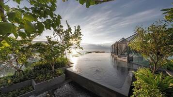 Een dakzwembad met een horizonuitzicht op de stadshemel, omringd door groen en moderne architectuur.