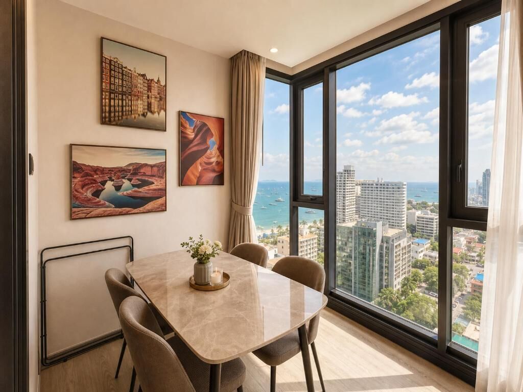 A dining area with a table and chairs, large windows with a city view, and artwork on the walls.