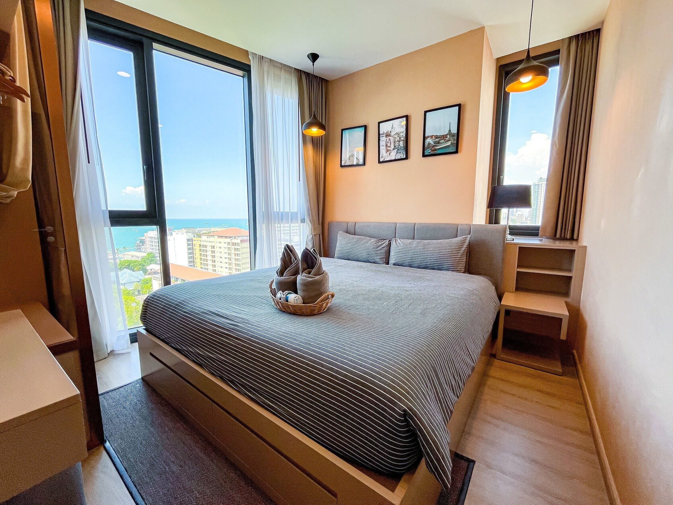 Una habitación de hotel moderna con una cama grande, vistas a la ciudad y un balcón.