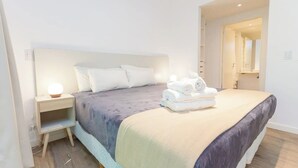 A modern hotel room with a large bed, a bedside table, and a nightstand. - Apartamento de 2 Ambientes en Belgrano (Buenos Aires)