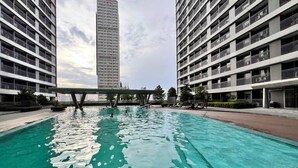 Une piscine entourée d’immeubles de grande hauteur dotés de balcons.
