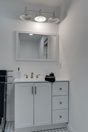 A modern bathroom with a white vanity, a large mirror, and three overhead lights. - Lakeview, 3-Bedroom Cottage, newly renovated (Dickson)