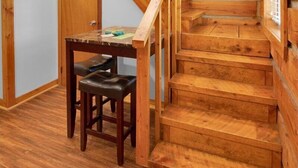 A wooden staircase with a handrail, leading to a loft area with a window. - Charming 1BR Smoky Mtn Cabin w/ Pool Access (Pigeon Forge)