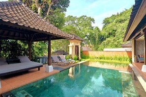A pool with lounge chairs, a covered seating area, and a small pavilion. - Villa Nirvana (Bali)