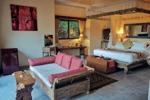 A bedroom with two beds, a desk, a chair, and a small table.