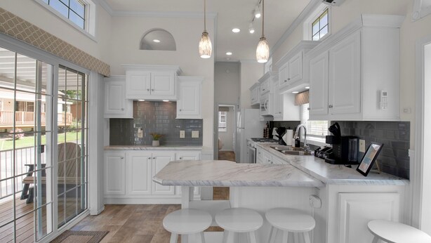 A spacious kitchen with white cabinetry, a marble countertop, and three bar stools. - Charming 1BR Cottage with Loft near Dollywood (Pigeon Forge)