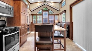 A kitchen with a large island, built-in appliances, and a dining area with a bench. - 1BR Cottage Retreat with Loft near Dollywood (Pigeon Forge)