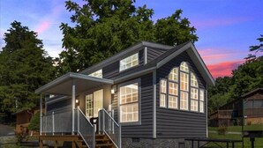 A two-story house with a porch, a staircase, and a stone foundation. - 1BR Cottage Retreat with Loft near Dollywood (Pigeon Forge)