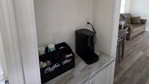 A kitchen with white cabinets, a coffee machine, and a coffee bar. - Pigeon Forge 2BR Cottage w/ King & Queen Beds (Pigeon Forge)