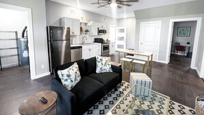 Un appartement moderne comprenant un salon, une cuisine et un coin repas.