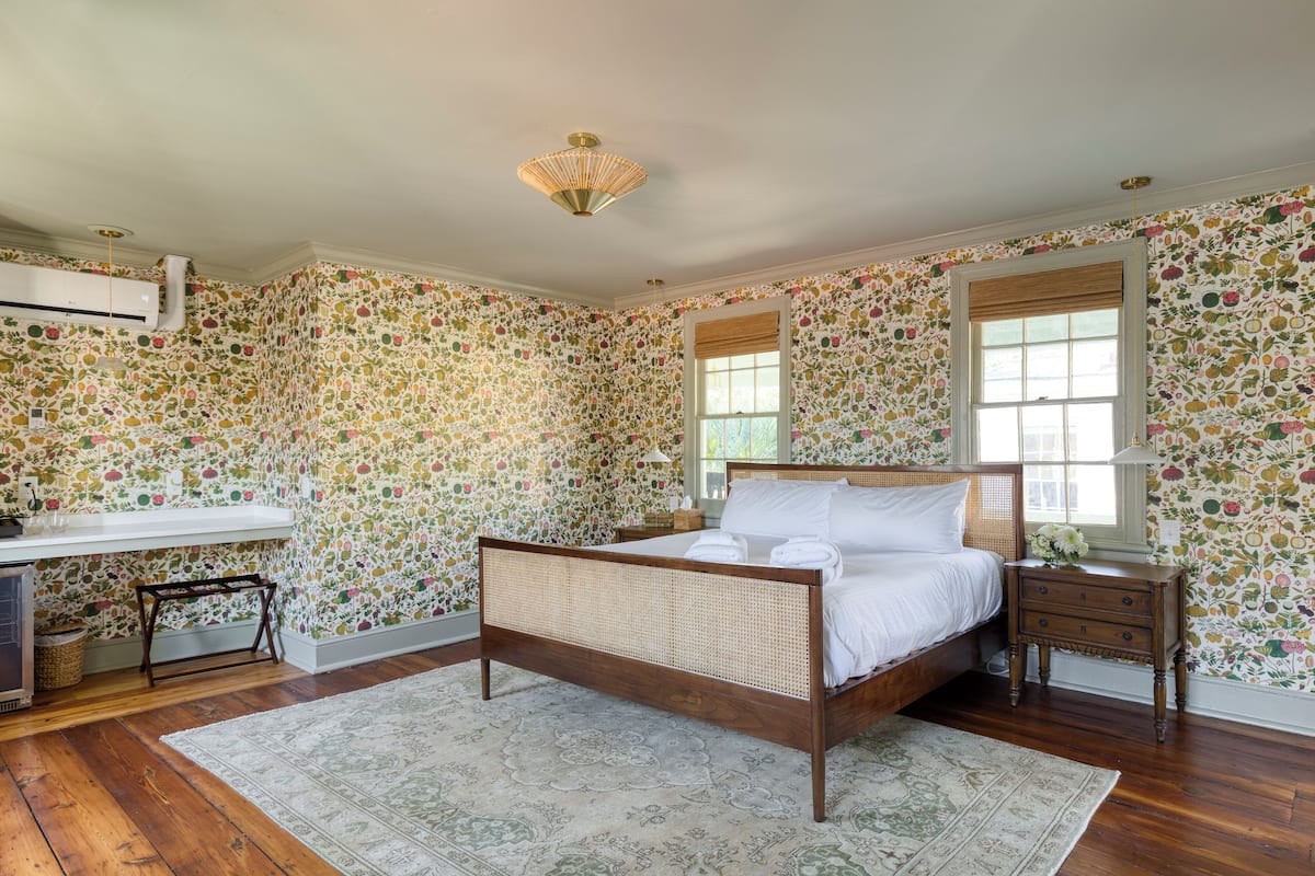 A bedroom with a wooden bed, a desk, and a chair.