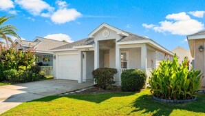 A single-story house with a garage, a covered porch, and a well-maintained lawn. - Hidden Palms! Next to Shipwreck Island! (Panama City Beach)