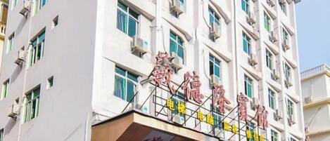 A multi-story building with a signboard displaying Chinese characters.
