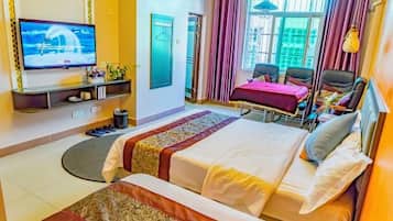 Een hotelkamer met een bed, een televisie, een bureau met stoel en een raam met gordijnen.