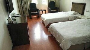Habitación de hotel con dos camas, un escritorio, una silla y un televisor.