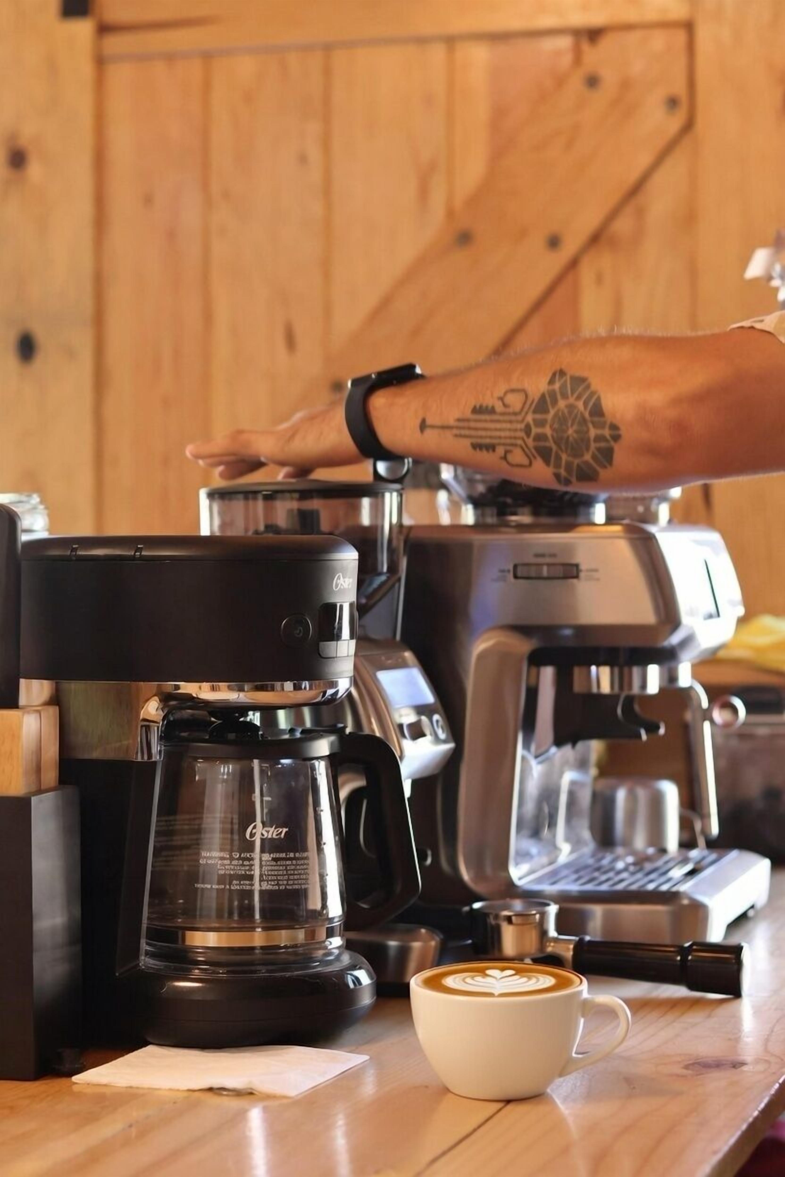 A coffee machine with a cup of coffee on a wooden table.