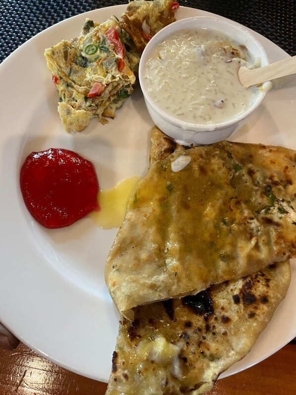 Une assiette avec un morceau de pain plat, un bol de soupe et une petite coupelle de sauce.
