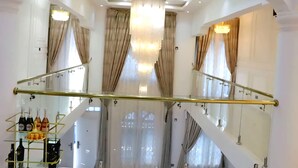 A luxurious interior with a grand chandelier, a glass railing, and a wine display. - 4BR Villa Pvt Pool, Rooftop. 10m walk to Beach. Starlink. Free Airport pick up  (Accra)