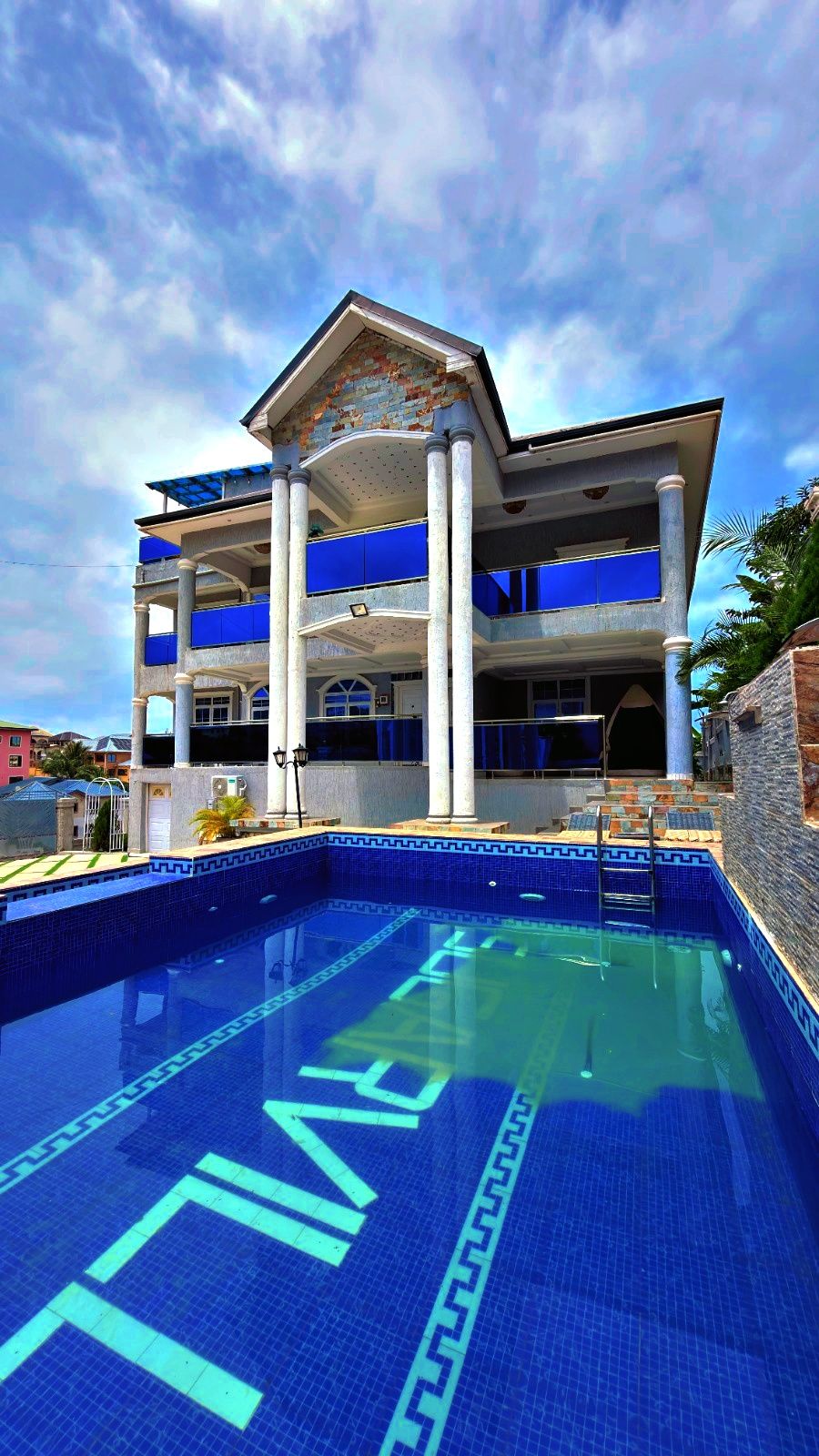 Un hôtel doté d’une piscine, de plusieurs balcons et offrant une vue sur un ciel dégagé.